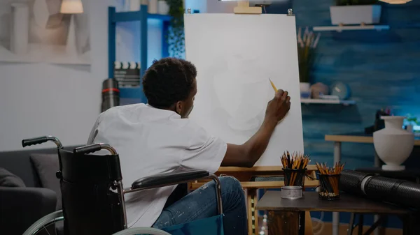 Schwarze Person mit Handicap mit Bleistift auf weißer Leinwand — Stockfoto