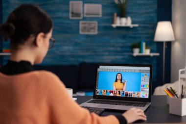 Öğrenci dizüstü bilgisayardaki fotoğrafları rötuşluyor.