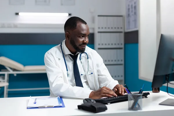 African american therapist doctor typing healthcare treatment on computer — Stock Photo, Image