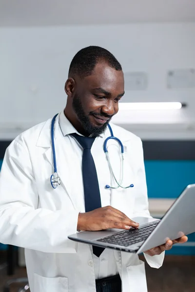 Africano americano terapeuta médico segurando laptop computador — Fotografia de Stock