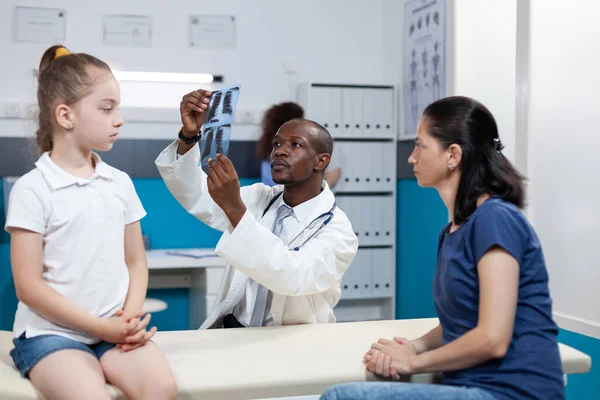 Médico pediatra afroamericano analizando radiografía pulmonar discutiendo síntomas de enfermedad —  Fotos de Stock