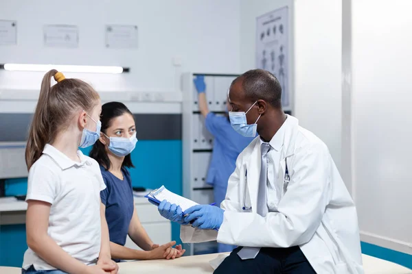 Médico pediatra afro-americano analisando sintomas de doença perícia — Fotografia de Stock