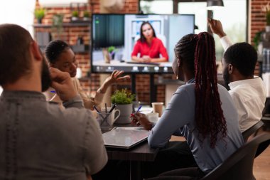 Uzak bir kadınla pazarlama stratejisini tartışan çeşitli iş adamları