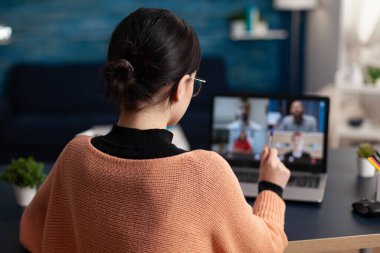 Evde çalışan öğrenci, web kamerası konferansında meslektaşlarıyla tartışıyor..