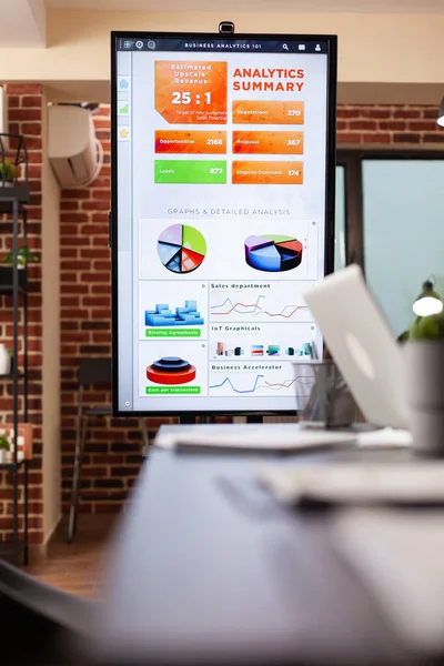 Monitor met management grafiek op het staan in lege startup bedrijf — Stockfoto