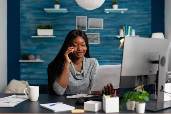 Αφροαμερικανοί ενήλικες συνομιλούν στο τηλέφωνο κάνοντας απομακρυσμένη εργασία — Φωτογραφία Αρχείου