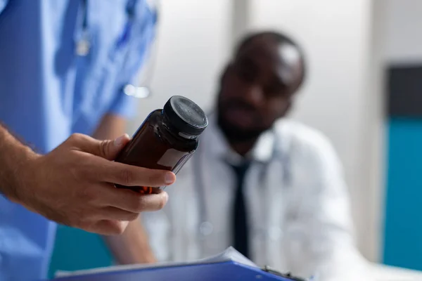 Closeup of caucasian man nurse holding pills bottle in hand — Stock Photo, Image
