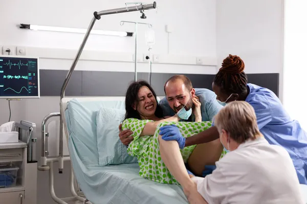 Young woman giving birth to child in hospital ward — Stock Photo, Image