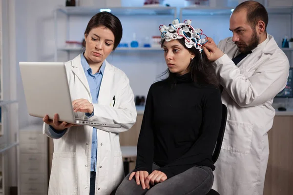 Ειδικός γιατρός κρατώντας φορητό υπολογιστή που δείχνει τομογραφία σε γυναίκα ασθενή — Φωτογραφία Αρχείου