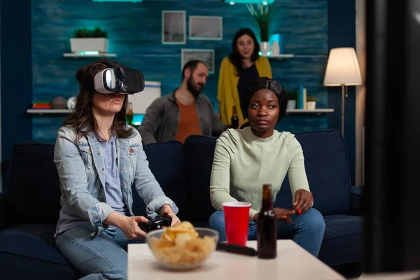 Gamer woman with virtual reality headset holding controller playing video games
