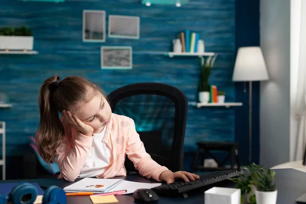 Втомилася нудна школярка, що має онлайн шкільний одон на комп'ютері — стокове фото