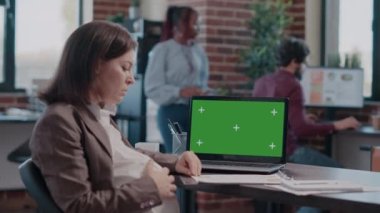 Yetişkinler bebek bekliyor ve laptopta yeşil ekranla çalışıyorlar.