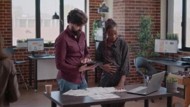 Tabletli bir iş adamı hamile meslektaşıyla konuşuyor.