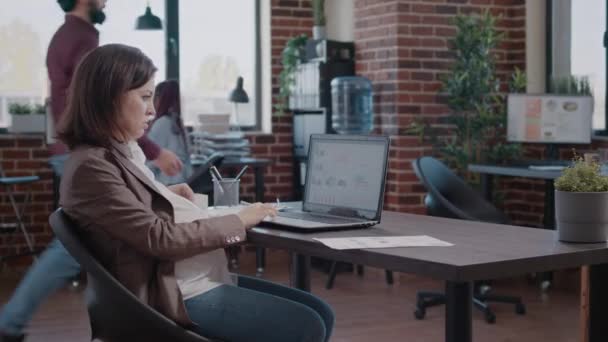 Těhotná obchodní žena pracující na notebooku pomocí dokumentů pro marketingové strategie — Stock video