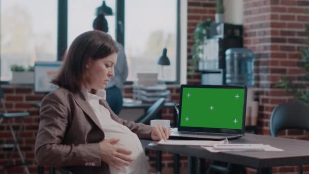 Gravid kvinna med bärbar dator med horisontell grön skärm — Stockvideo