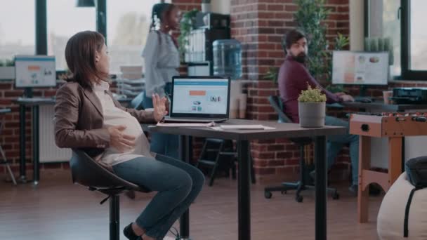 Schwangere Mitarbeiterin arbeitet mit Laptop an Geschäftsprojekt — Stockvideo