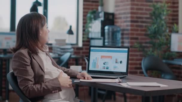 Detailní záběr těhotné ženy drží ruku na břiše pracuje na obchodní strategii — Stock video