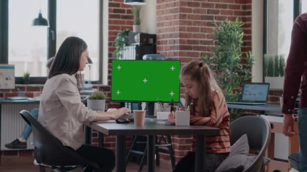 Madre trabajadora usando pantalla verde horizontal en la computadora y niña garabateando — Vídeo de stock