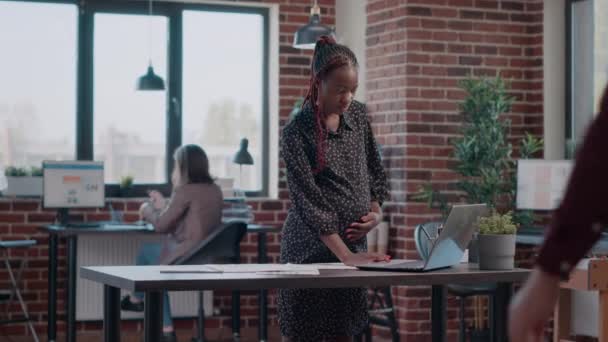 Zakenman helpt zwangere vrouw met projectplanning op het werk — Stockvideo