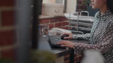 İş projesinde çalışmak için monitöre bakan Asyalı kadın