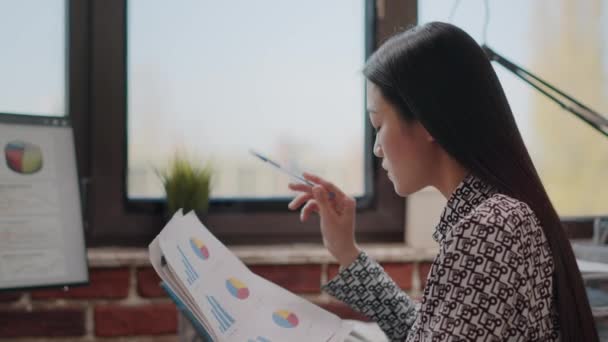 Close up of woman comparing charts on papers and computer — Stock Video