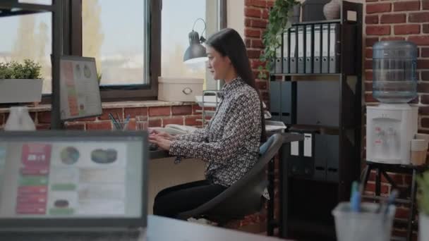 Asian business woman using computer to work on project — Stock Video