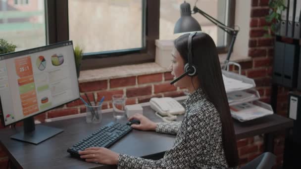 Close up de mulher asiática com fones de ouvido falando por telefone — Vídeo de Stock