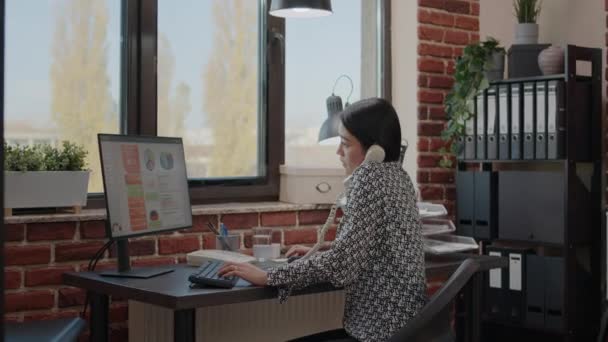 Mujer de negocios trabajando y hablando por teléfono fijo — Vídeo de stock