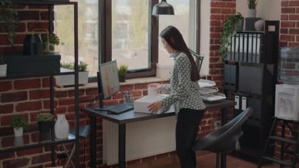 Woman packing up belongings in box after getting fired — Stock Video