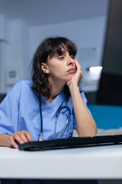 Tired woman having head in hand and looking at monitor display — Stock Photo, Image