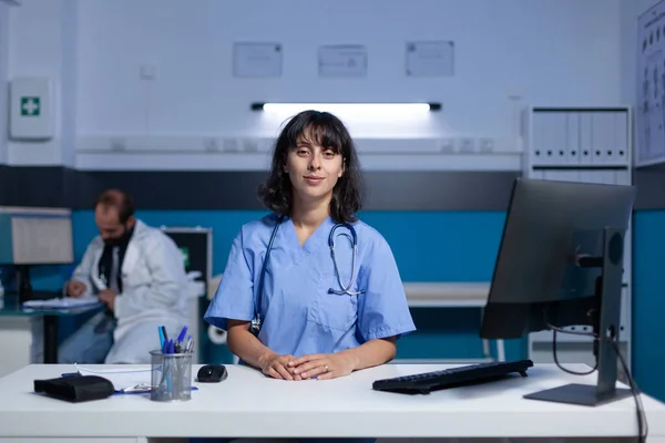 Retrato de assistente médico usando computador na mesa de trabalho — Fotografia de Stock