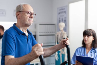 Hasta spor aletleri ve teçhizatla egzersiz yapıyor.