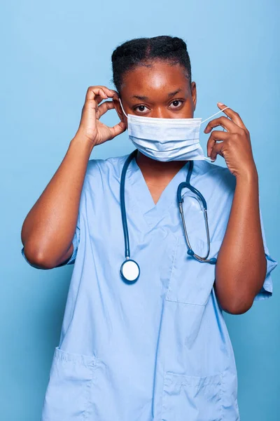 Afrikaanse amerikaanse therapeut assistent zetten bescherming gezichtsmasker — Stockfoto