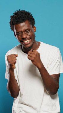 Kızgın adam stüdyoda duygularını gösteriyor ve yumruklarını sıkıyor.