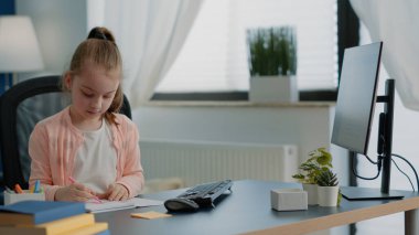 Not defterine renkli kalemlerle çizim yapan liseli kız.