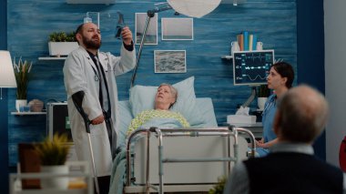 Hastalıklı yaşlı bir hasta doktordan ziyaret alıyor.