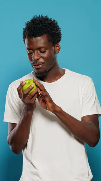 Vegetarian man playing with green apple in studio — Stock Photo, Image