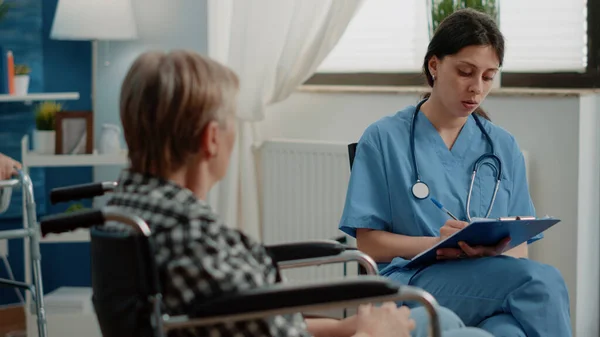 Woman nurse examining healthcare of retired patient — Stock Photo, Image