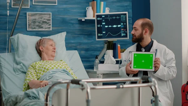 平板电脑上有水平绿色屏幕的医生与病人交谈 — 图库照片