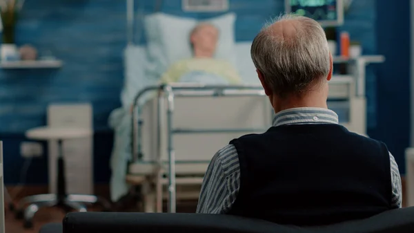 Großaufnahme eines älteren Mannes, der seiner kranken Frau hilft — Stockfoto