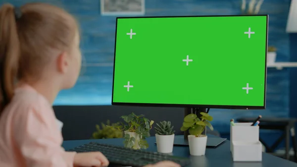 Chica joven mirando al monitor con pantalla verde horizontal — Foto de Stock