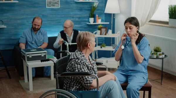 坐轮椅的退休妇女接受护士的咨询 — 图库照片
