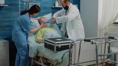 Doktor ve hemşire canlandırma için oksijen tüpü kullanıyor.