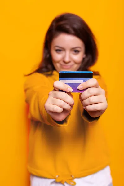 Retrato de mujer alegre sosteniendo tarjeta de crédito en la cámara —  Fotos de Stock