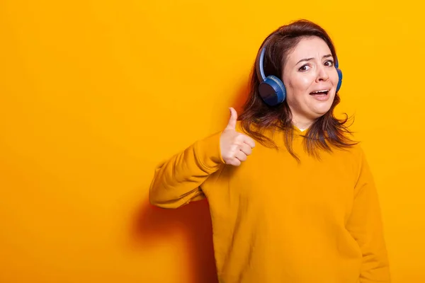 Femme joyeuse portant des écouteurs pour écouter de la musique — Photo
