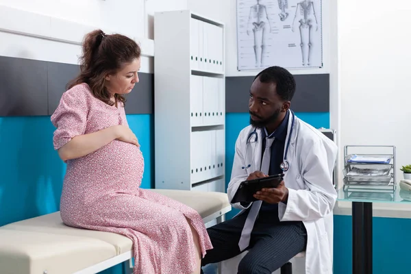 Mulher esperando criança e tendo discussão com o médico — Fotografia de Stock