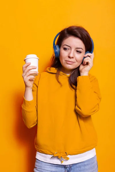 Pessoa alegre com xícara de café ouvindo música em fones de ouvido — Fotografia de Stock