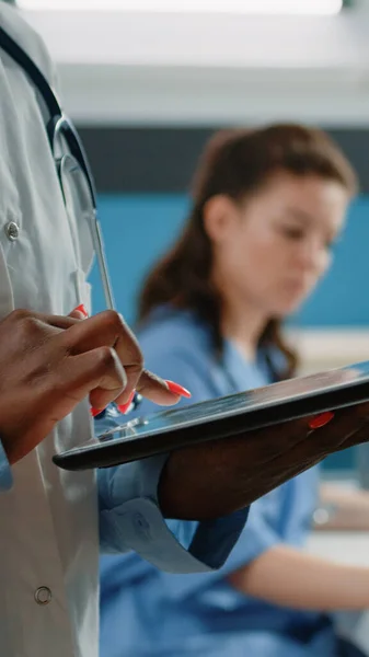Close-up van Afrikaanse Amerikaanse arts met behulp van tablet met touchscreen — Stockfoto