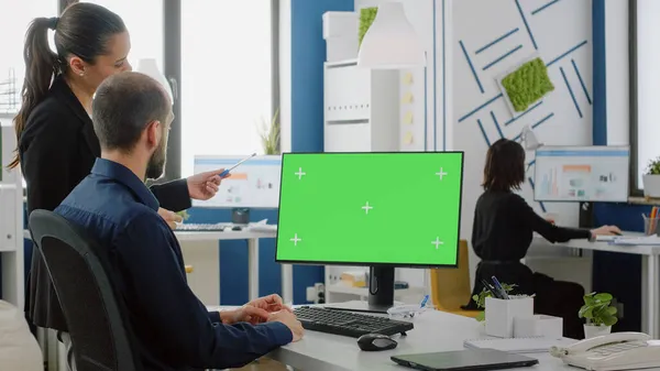 Werkgenoten kijken naar bureau met groen scherm op monitor — Stockfoto