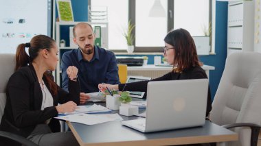 Bilgisayar kullanan meslektaşlar ve veri tablosu olan kağıtlar